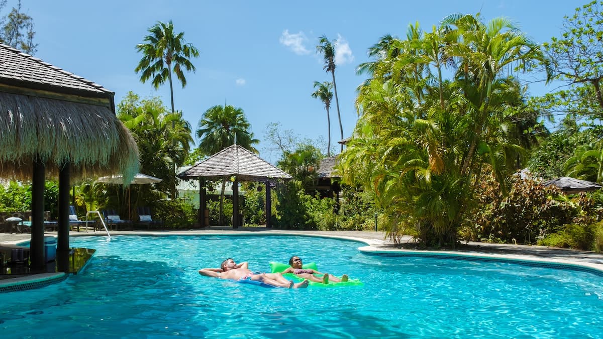 Man and woman floating in pool on vacation in luxury resort as part of exclusive Worldgo deals