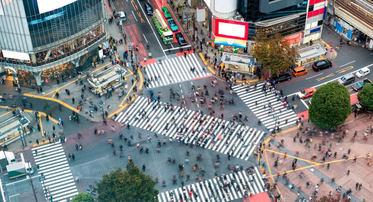 Aerial view of Pedestrians walking across with crowded traffic at Shibuya crossing square