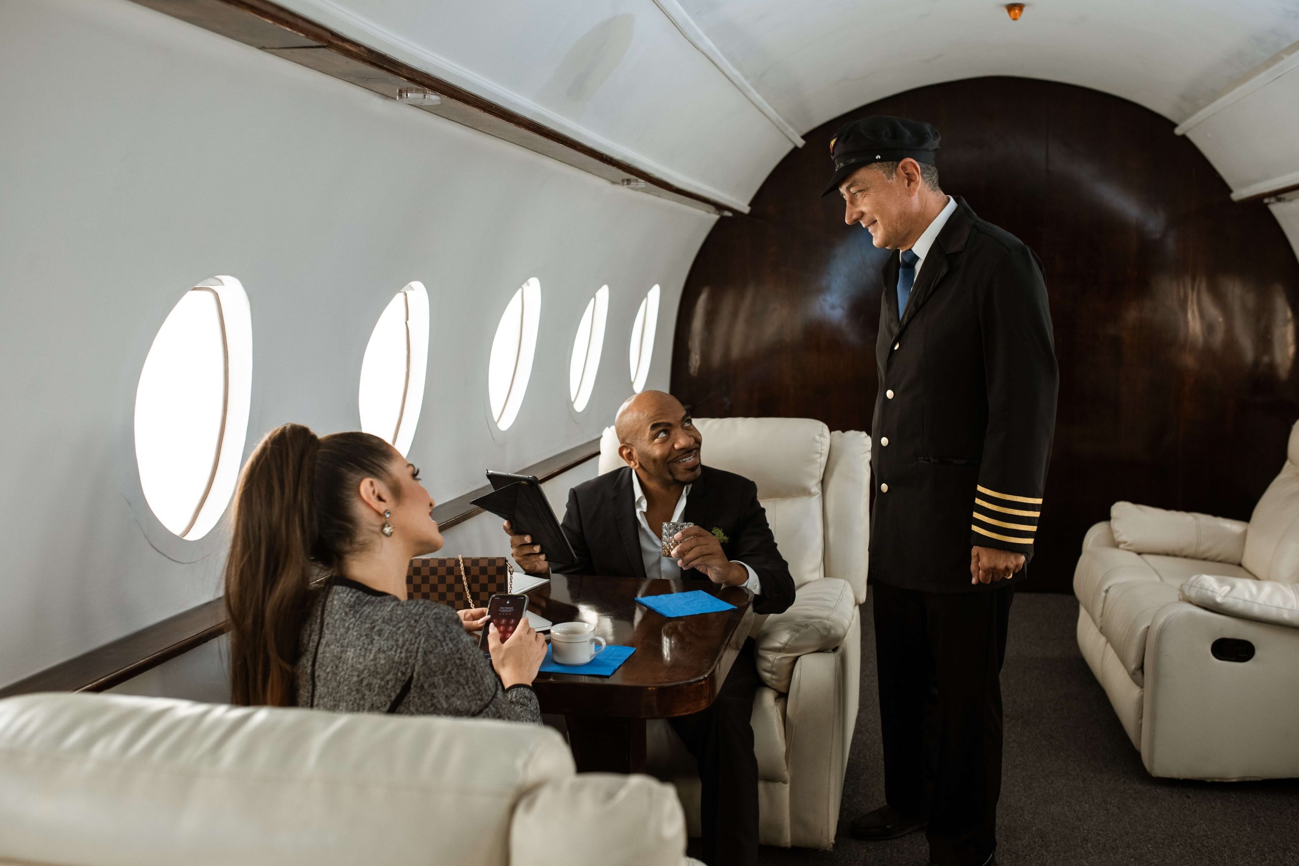 Two business professionals engaged in a conversation on a luxurious private jet, highlighting the convenience and exclusivity of private jet rentals for business travel