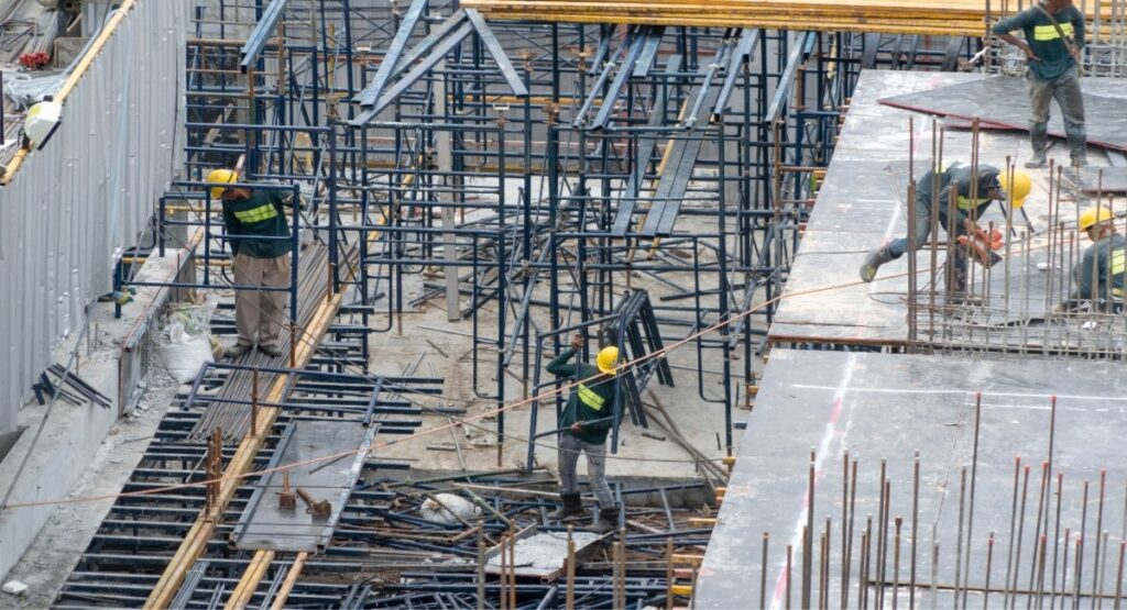 Construction crew working on a large-scale building site with steel scaffolding